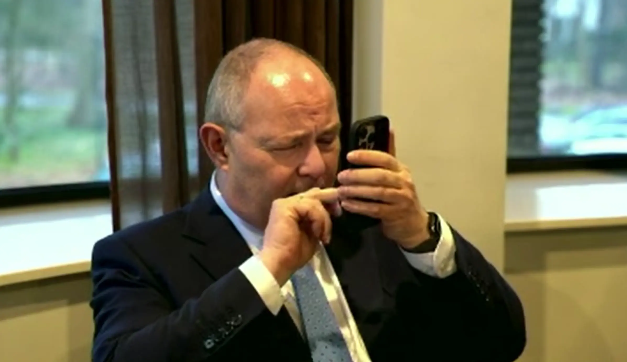 Marcel Oosterveer zoekt iets op op zijn smartphone.